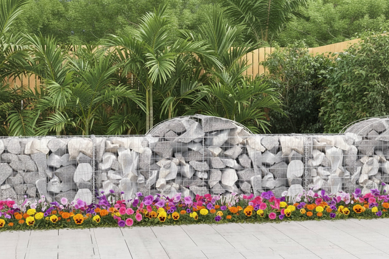 Gabion wall made of stacked stones with a wooden fence and trees in the background