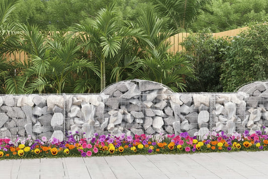 Gabion wall made of stacked stones with a wooden fence and trees in the background
